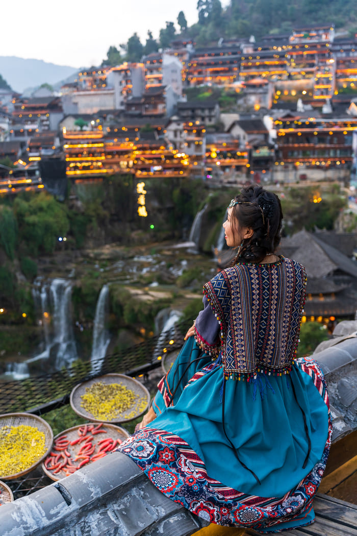 Mujer sentada admirando la ciudad Iijang en China